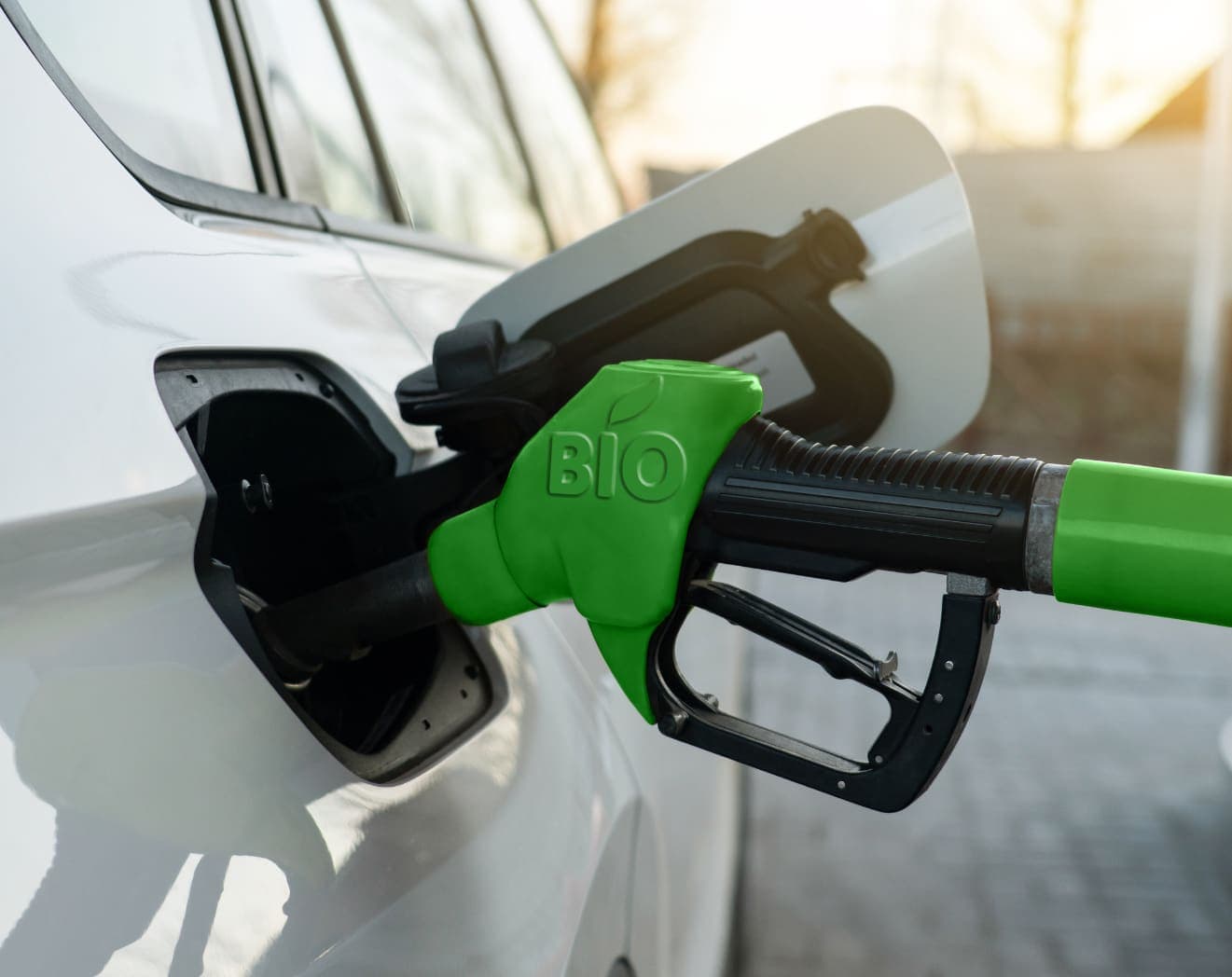 A nozzle marked BIO in the filler neck of a white car.